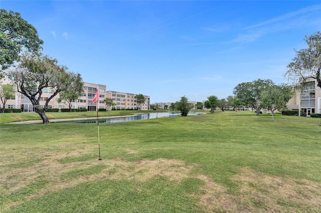 view of community with a lawn and a water view