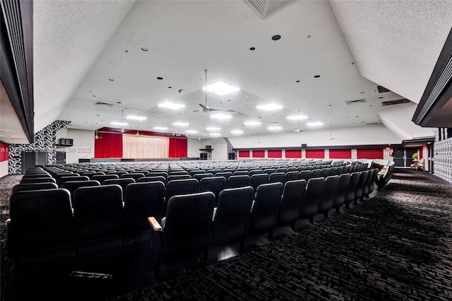 home theater room with carpet floors, a textured ceiling, and visible vents