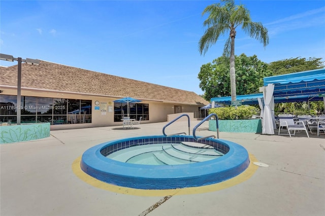 view of pool featuring a community hot tub and a patio area