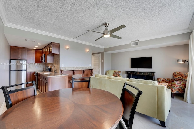 dining area featuring crown molding, ceiling fan, and visible vents
