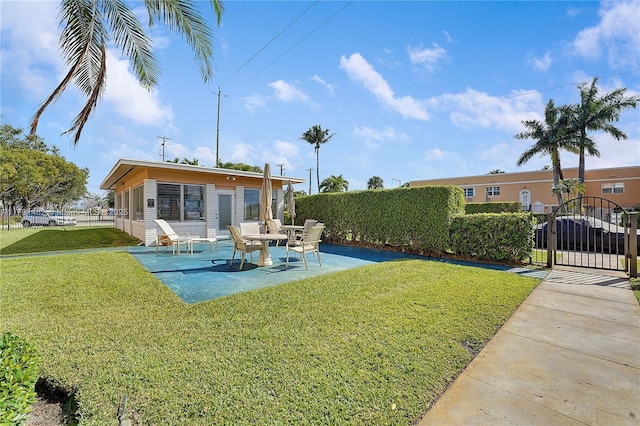 rear view of property with fence, a gate, a patio, and a yard