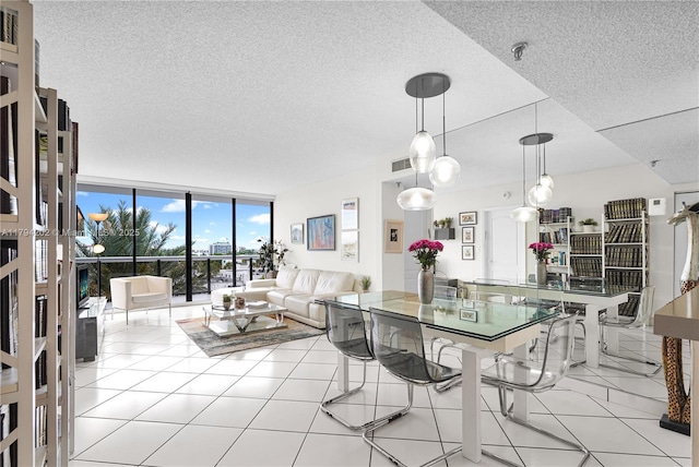 dining space featuring a textured ceiling, tile patterned floors, expansive windows, and visible vents