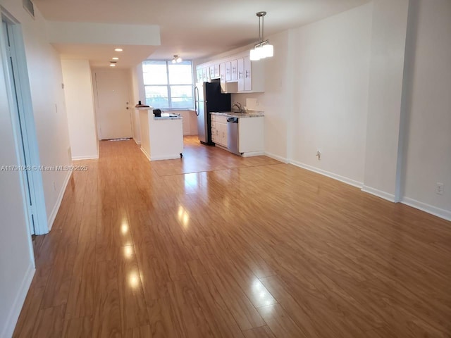 unfurnished living room featuring baseboards, light wood finished floors, and visible vents