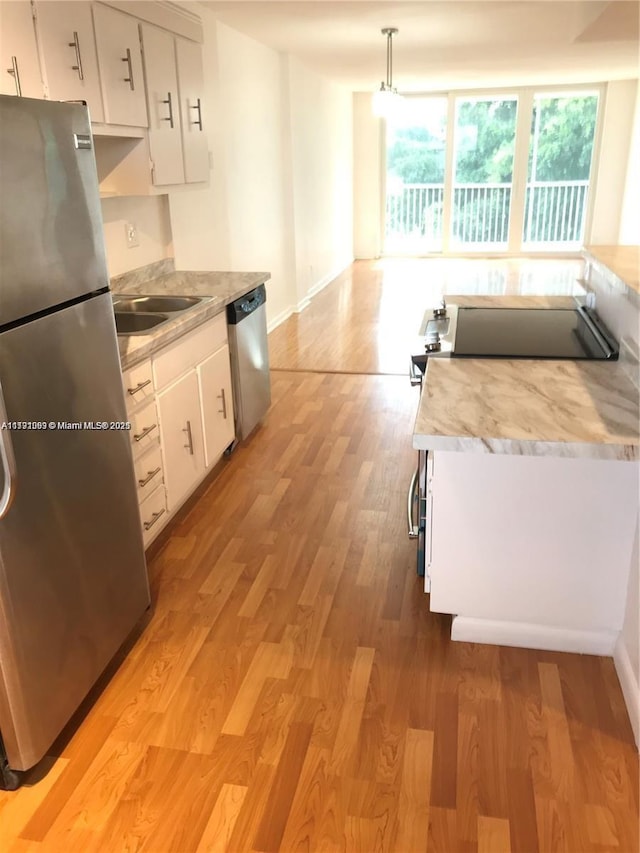 kitchen with plenty of natural light, light countertops, white cabinetry, and stainless steel appliances