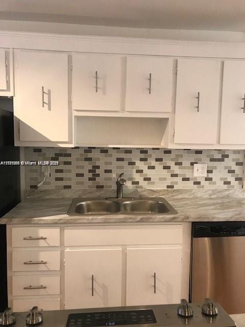kitchen with a sink, light countertops, stainless steel dishwasher, and white cabinetry