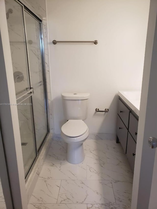 bathroom with vanity, marble finish floor, a marble finish shower, and toilet