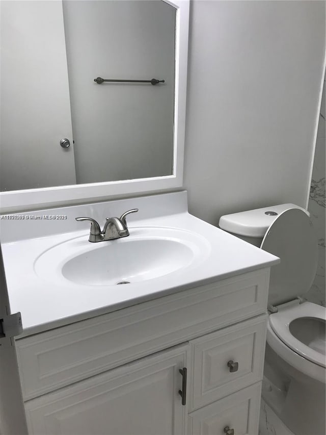 bathroom featuring vanity, marble finish floor, and toilet
