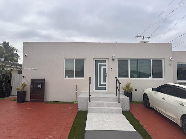 view of front of house with stucco siding and fence