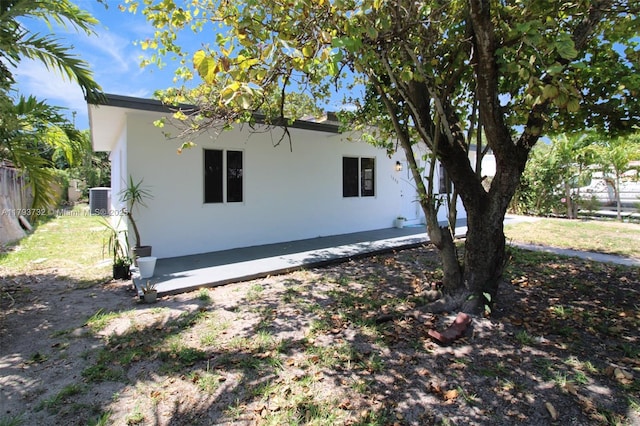 view of side of property with fence and stucco siding