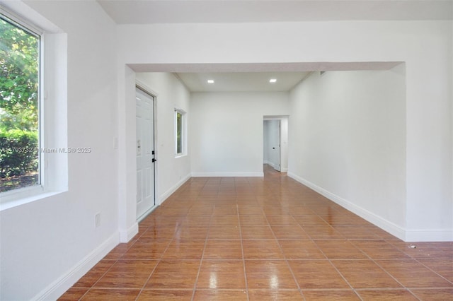spare room with plenty of natural light, recessed lighting, and baseboards