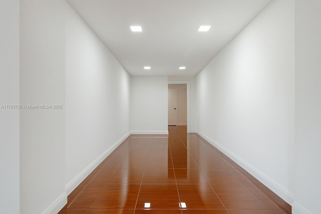 corridor with baseboards, recessed lighting, and tile patterned floors