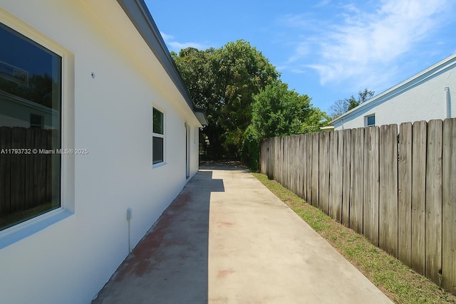 view of home's exterior featuring fence, stucco siding, and a patio area