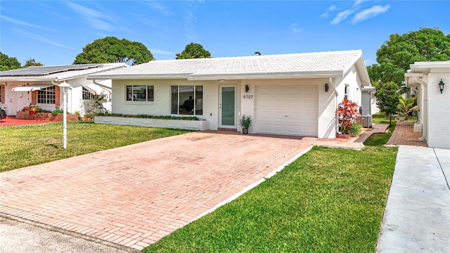 ranch-style house featuring decorative driveway, a garage, a front lawn, and stucco siding