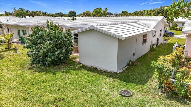 view of side of property featuring stucco siding and a yard