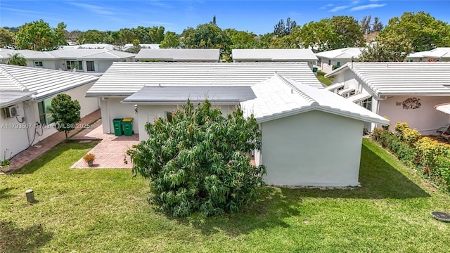 back of house with a residential view, stucco siding, a yard, and a patio area