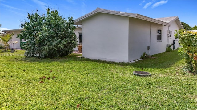 view of side of property with a yard and stucco siding