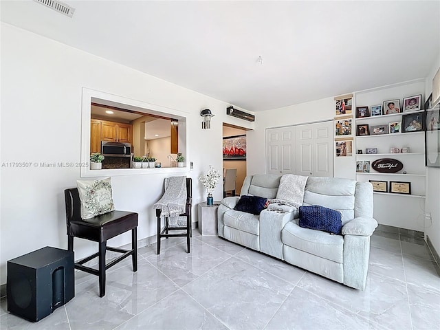 living area featuring visible vents, marble finish floor, and baseboards