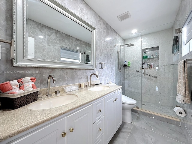 bathroom featuring a sink, a stall shower, marble finish floor, and visible vents