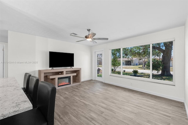 1531 NE 32nd St, Pompano Beach, FL 33064 - living area featuring baseboards, a glass covered fireplace, wood finished floors, and ceiling fan