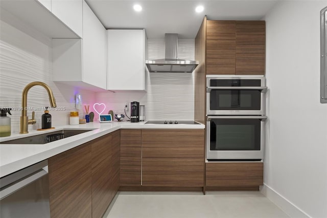 kitchen with wall chimney range hood, a sink, stainless steel appliances, decorative backsplash, and modern cabinets