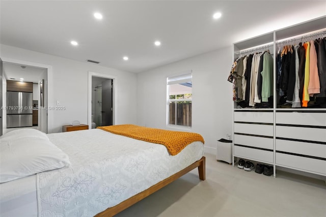 bedroom with visible vents, ensuite bathroom, recessed lighting, stainless steel built in fridge, and finished concrete floors