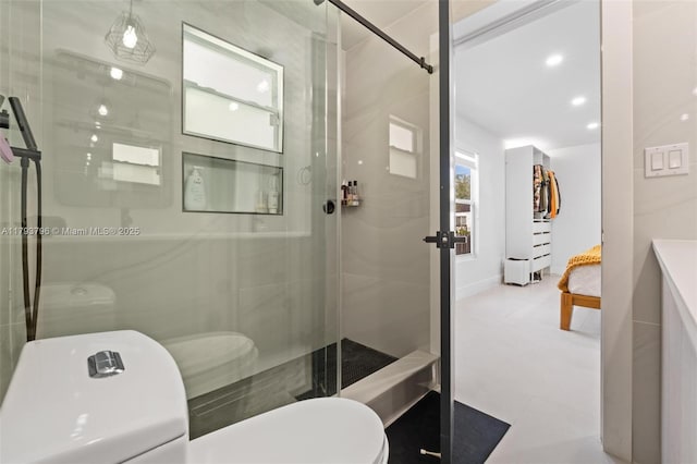 bathroom featuring tile patterned flooring, toilet, and a shower stall