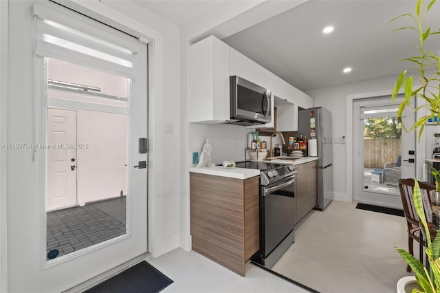 kitchen with light countertops, stainless steel appliances, a sink, and modern cabinets