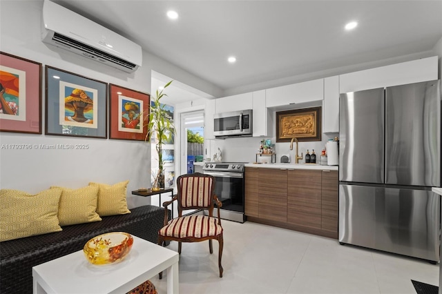 kitchen with recessed lighting, light countertops, white cabinetry, a wall unit AC, and appliances with stainless steel finishes
