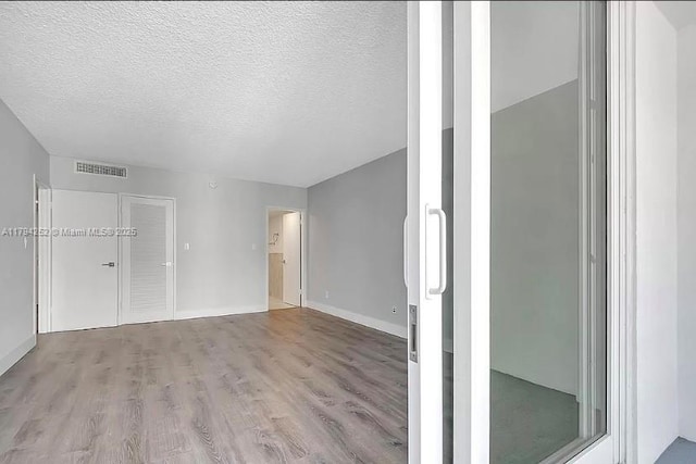 5401 Collins Ave Unit 411, Miami Beach, FL 33140 - interior space with visible vents, a textured ceiling, baseboards, and light wood-type flooring