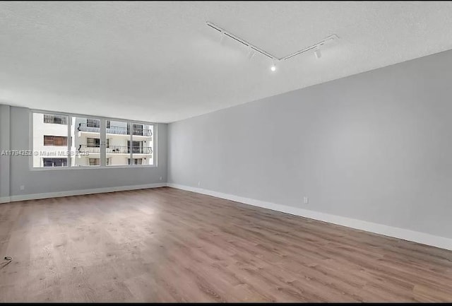 5401 Collins Ave Unit 411, Miami Beach, FL 33140 - spare room with baseboards, rail lighting, wood finished floors, and attic access