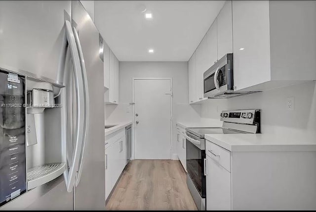5401 Collins Ave Unit 411, Miami Beach, FL 33140 - kitchen with appliances with stainless steel finishes, light wood-style floors, light countertops, white cabinetry, and modern cabinets