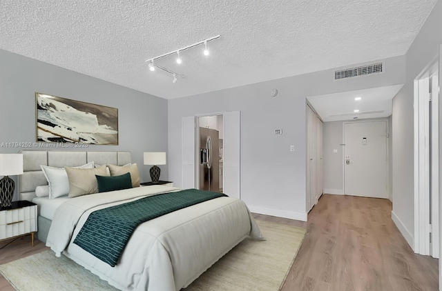 5401 Collins Ave Unit 411, Miami Beach, FL 33140 - bedroom featuring stainless steel refrigerator with ice dispenser, a textured ceiling, visible vents, and light wood-type flooring