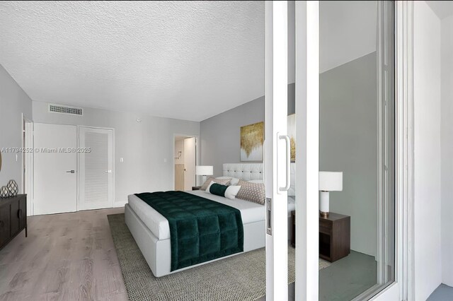 5401 Collins Ave Unit 411, Miami Beach, FL 33140 - bedroom with a textured ceiling, visible vents, and wood finished floors