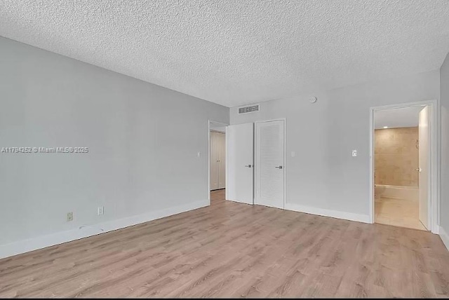 5401 Collins Ave Unit 411, Miami Beach, FL 33140 - unfurnished bedroom with a closet, a textured ceiling, visible vents, and light wood-style floors