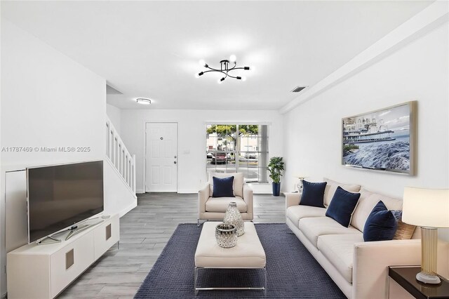2917 NW Belmont Ln Unit 2917, Cooper City, FL 33026 - living area with visible vents, light wood-style flooring, stairs, and a notable chandelier