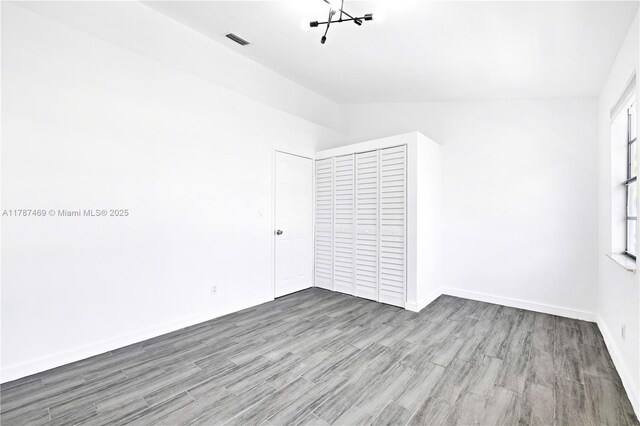 2917 NW Belmont Ln Unit 2917, Cooper City, FL 33026 - spare room with visible vents, baseboards, lofted ceiling, and wood finished floors