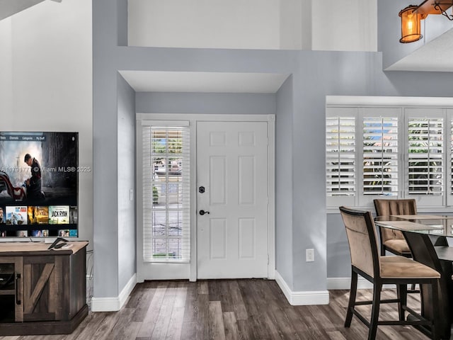 foyer with baseboards and wood finished floors