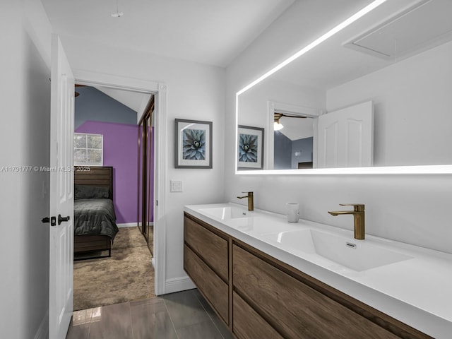ensuite bathroom with a sink, baseboards, ensuite bath, and double vanity