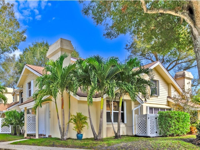 view of front of property with a chimney and stucco siding