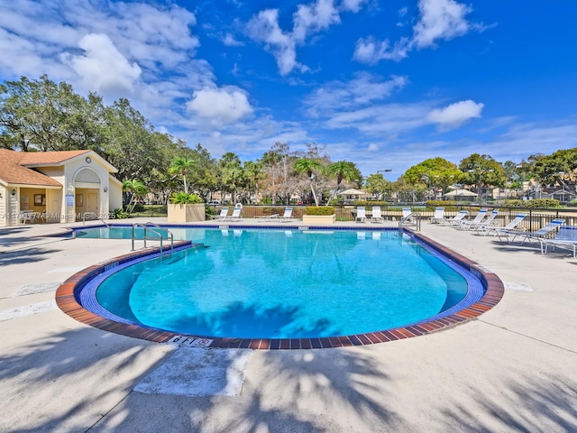 pool with a patio and fence