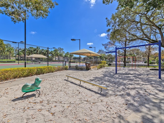 view of property's community with a gazebo, fence, a tennis court, and playground community