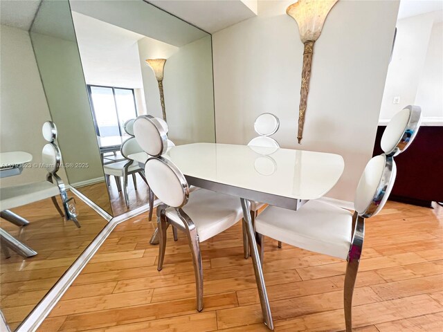 dining space featuring baseboards and light wood-type flooring