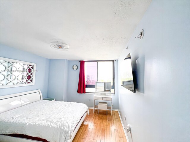 bedroom featuring baseboards and hardwood / wood-style floors