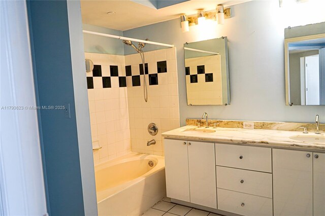 full bath with double vanity, a sink, washtub / shower combination, and tile patterned floors