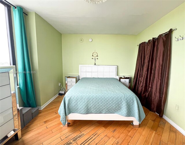 bedroom with baseboards and hardwood / wood-style flooring