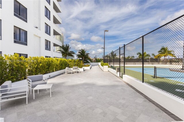 view of home's community with fence and a tennis court