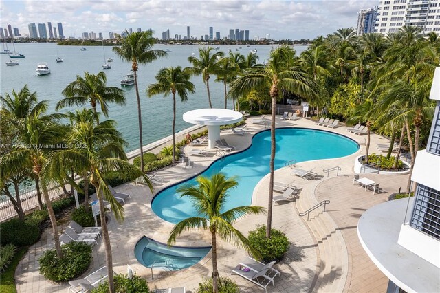 view of swimming pool with a view of city and a water view