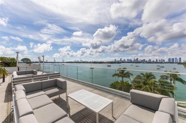 view of patio / terrace with a water view, an outdoor living space, and a city view