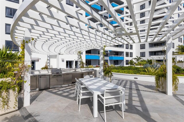 view of patio with a pergola, exterior kitchen, outdoor dining area, a sink, and a grill