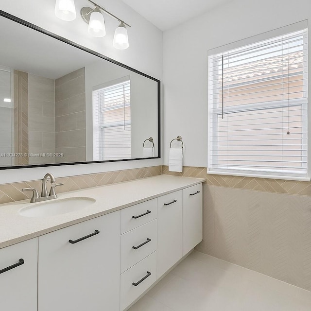 bathroom with tile walls, tile patterned flooring, and vanity